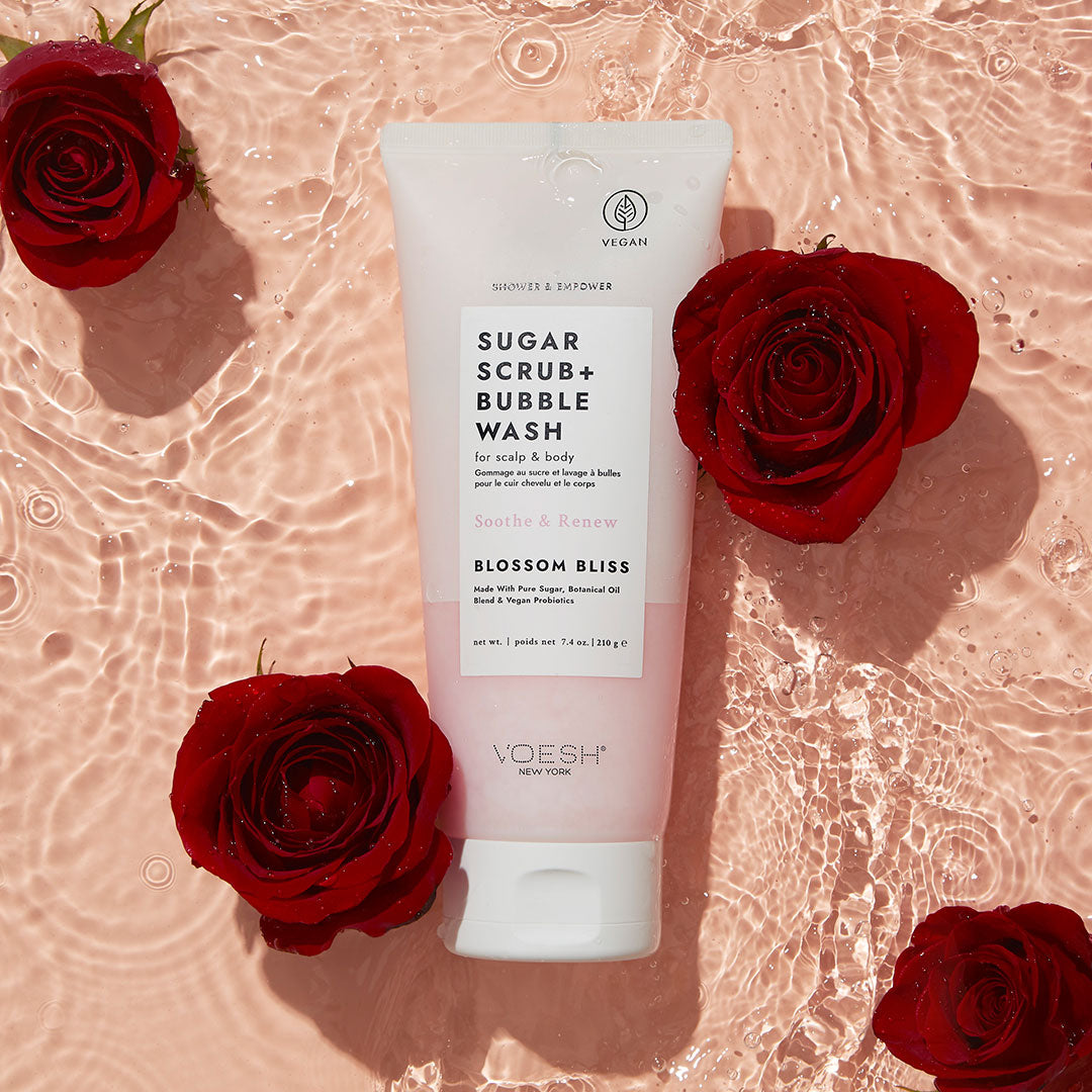 Blossom Bliss Shower & Empower Sugar Scrub on pink background with roses in water